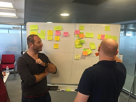picture of two people discussing in a workshop near a whiteboard